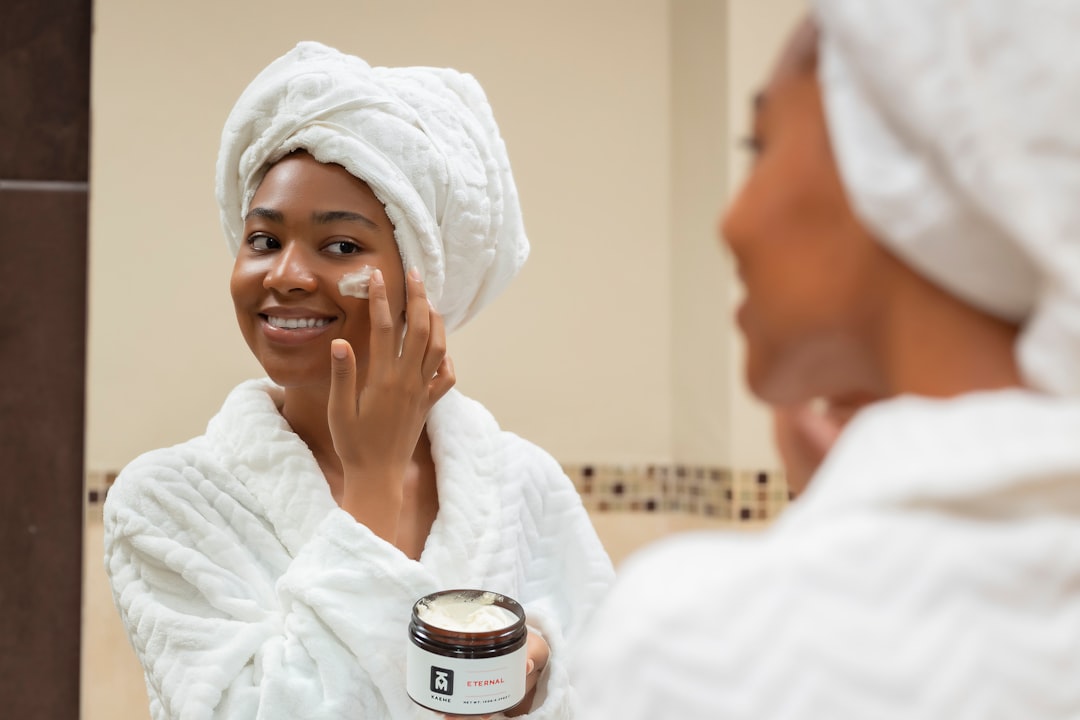 A woman following a simplified skin protection routine with moisturiser and SPF at home