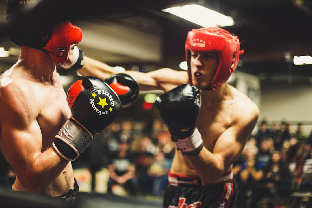 A boxing coach correcting a beginner's stance at a boxing gym, demonstrating proper technique in a London training session