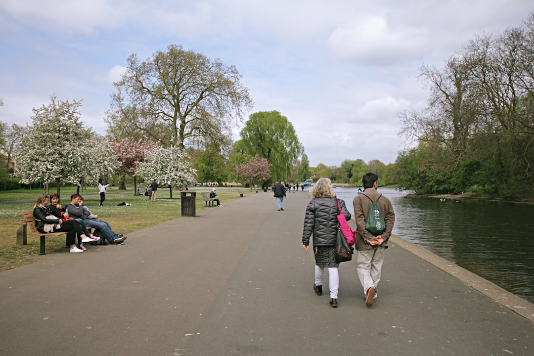 A couple walking through a London park on a sunny bank holiday weekend afternoon
