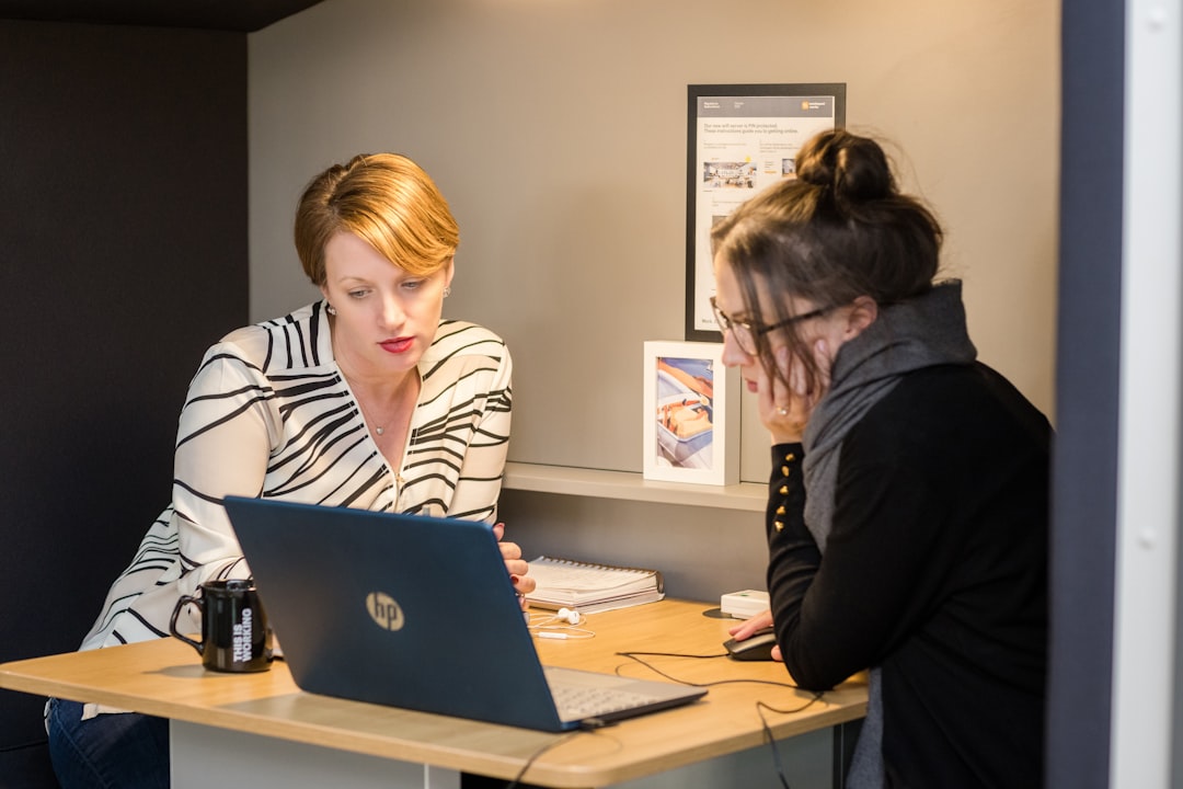 2 startup founders discuss strategy with a business mentor at a London coworking hub