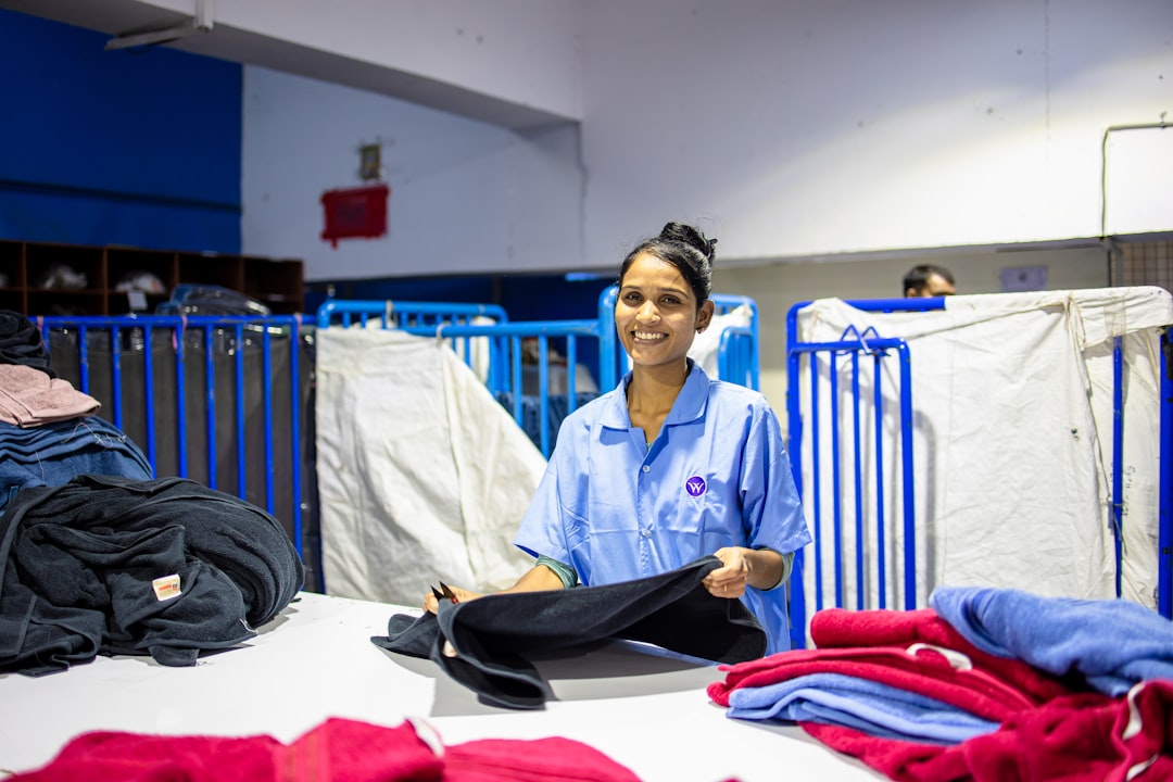 A woman carefully folding clean garments into a donation bag to give to charity shops in her London neighbourhood