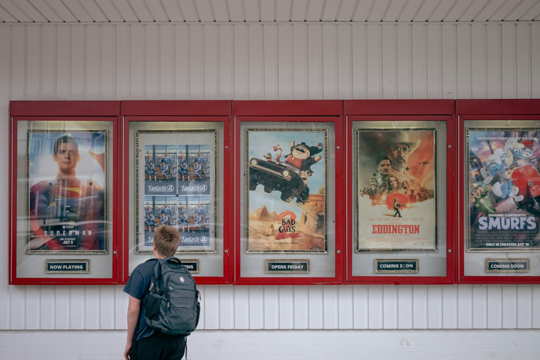 A man standing in a cinema lobby reading the seasonal programme at an independent London cinemas venue