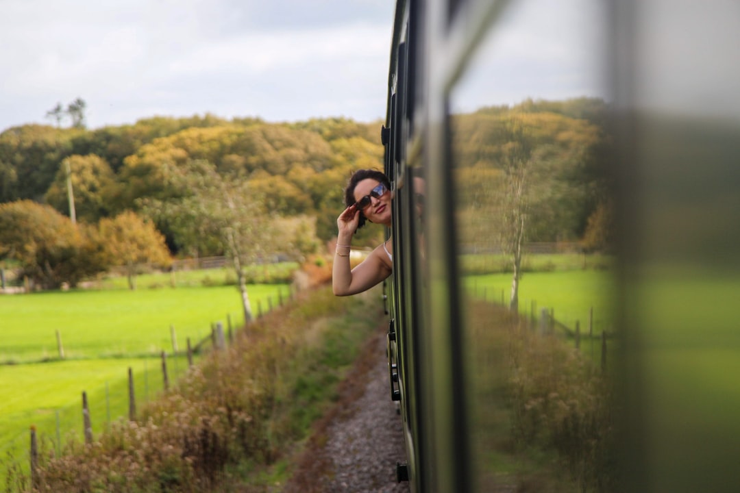 A traveller gazes out of a train window at an autumn countryside during one of the most scenic weekend escapes from London.
