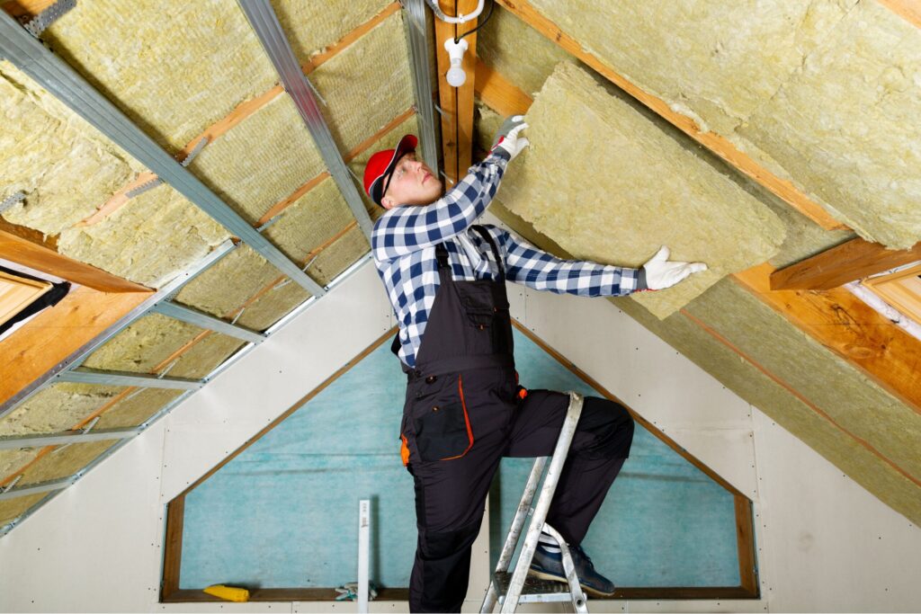 _Homeowner performing essential weatherproofing maintenance on winter home exterior