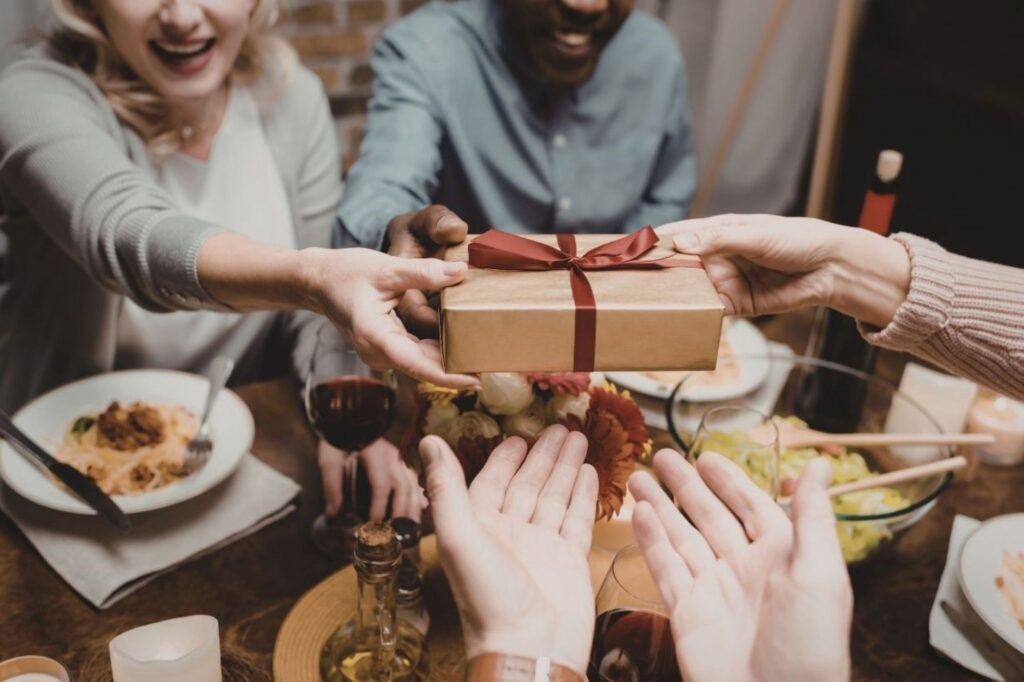 European family joyfully exchanging Christmas gifts in cozy living room demonstrating holiday stress relief through meaningful connections, simplified celebrations, and focus on quality time over perfectionism during festive season