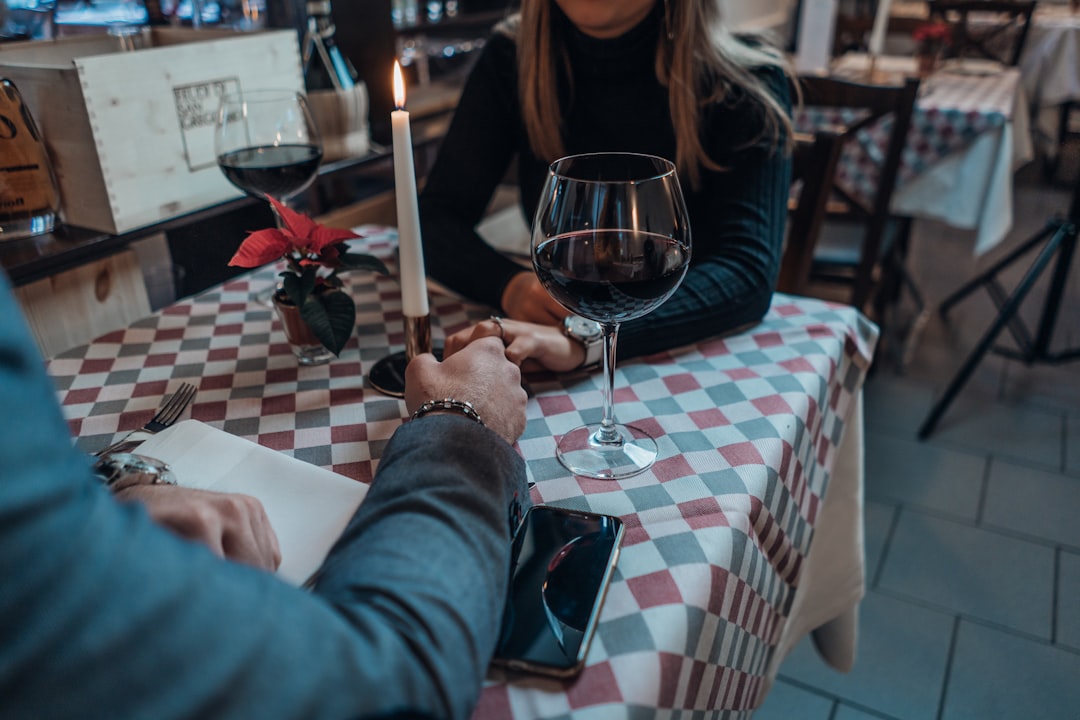 A couple asking a restaurant waiter about allergen labels and gluten-free menu options while dining out in Europe