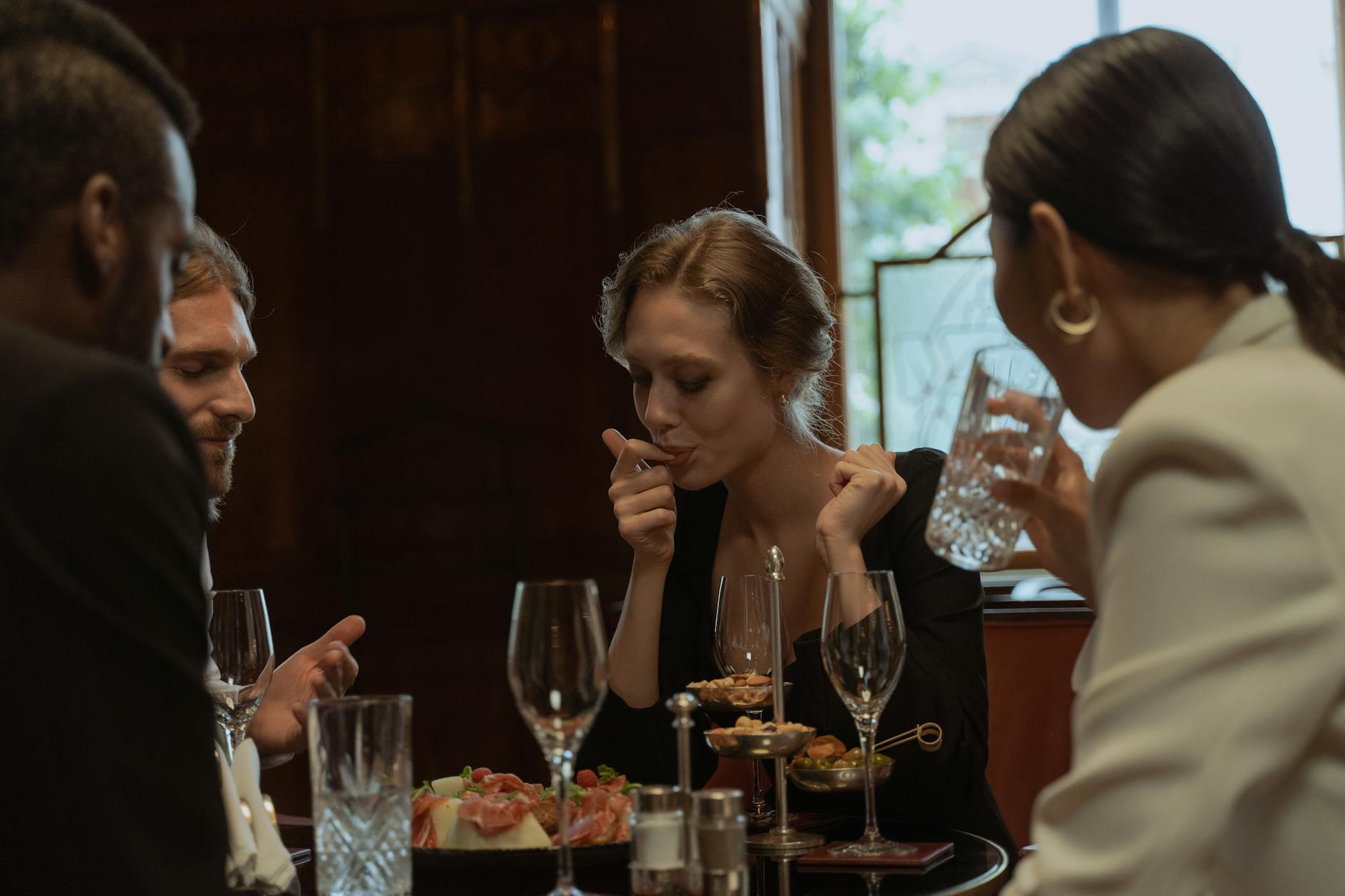 A group of friends dining together at a gluten-free Paris restaurant, sharing plates and smiling at the table