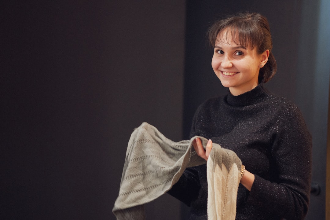 A fashion-conscious woman inspects certified sustainable fabric, looking for authentic EU Ecolabel certification marks
