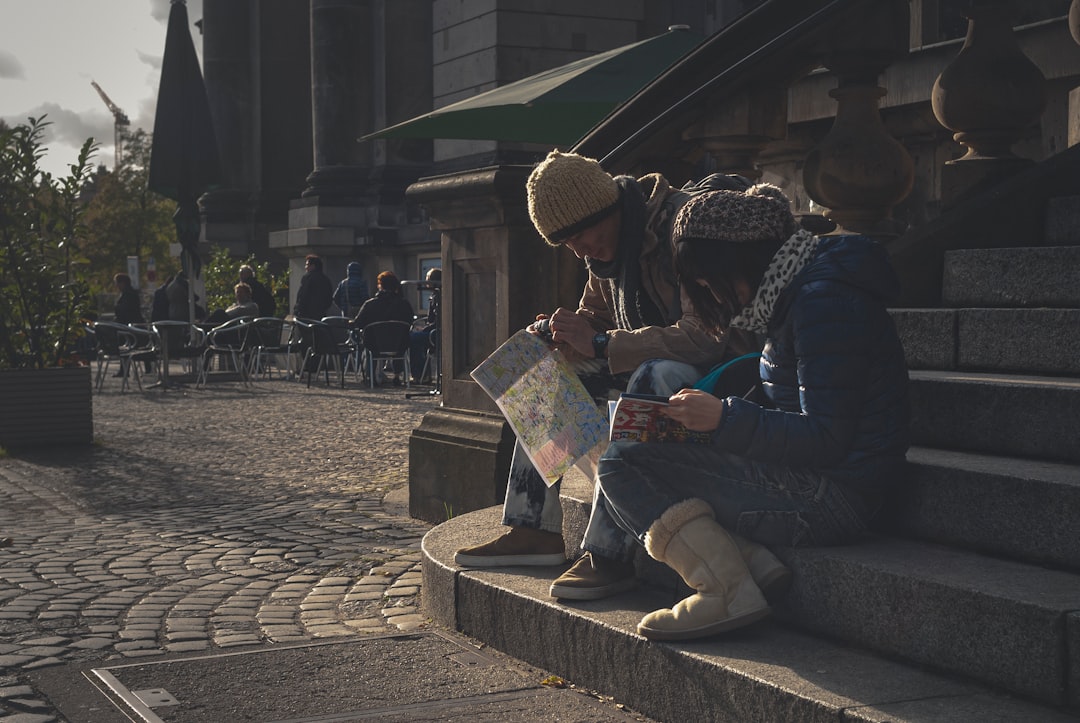 A couple exploring fresh fruit and artisan goods at a vibrant EU farmers market on a summer morning.