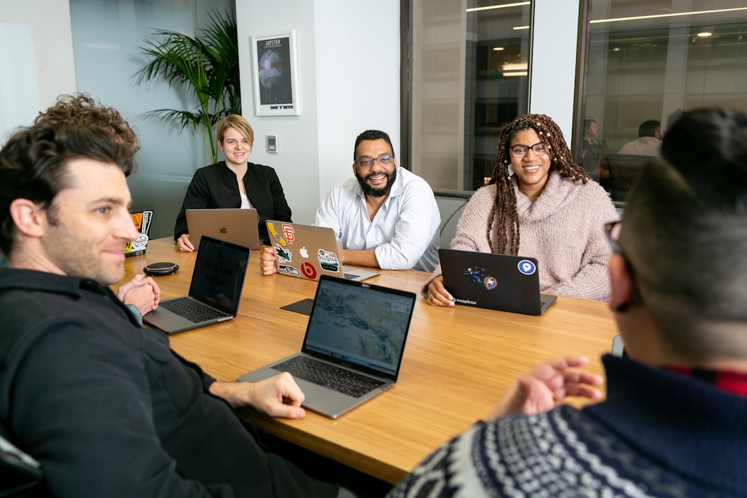 Two colleagues review compliance documents during an EU subsidiary registration process at a shared workspace.