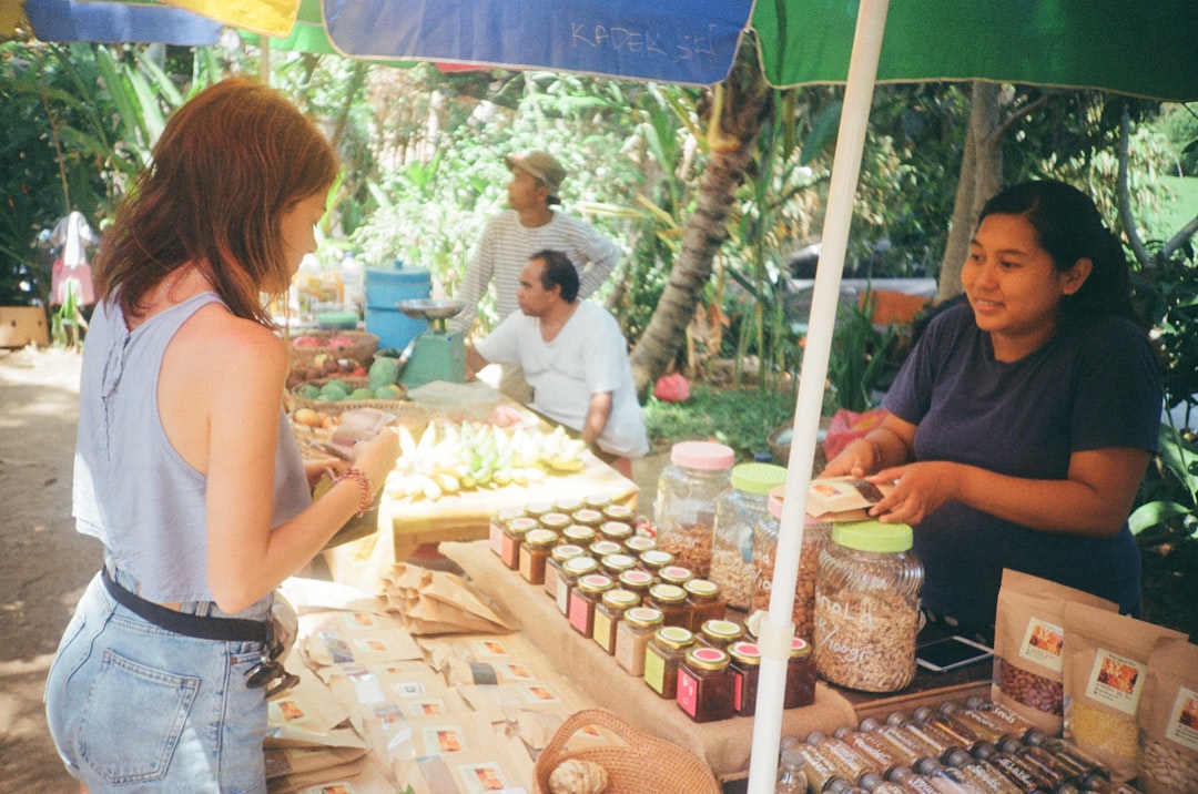 An artisan vendor presenting local cheeses at a traditional EU farmers market stall.