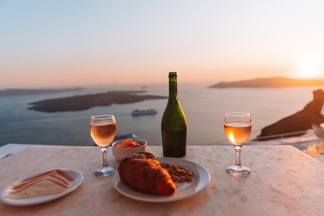 A traveller enjoys a sunset EU vineyard tasting on Santorini's volcanic terraces overlooking the Aegean caldera