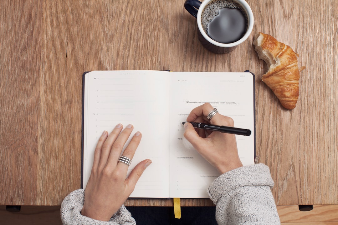 A woman writing in a journal over a light breakfast at a European café, completing her morning routine.