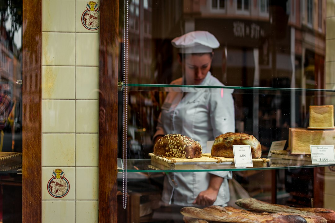 A female baker measuring gluten-free flours including chestnut and teff into a ceramic bowl for autumn baking