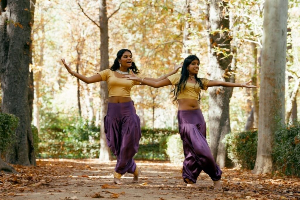 Two friends learning classical arts dance outdoors showing traditional Indian dance education and cultural revival