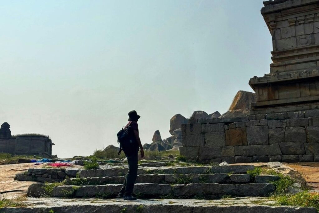 Tourists at Hampi heritage tourism site showing cultural economics and archaeological monument business