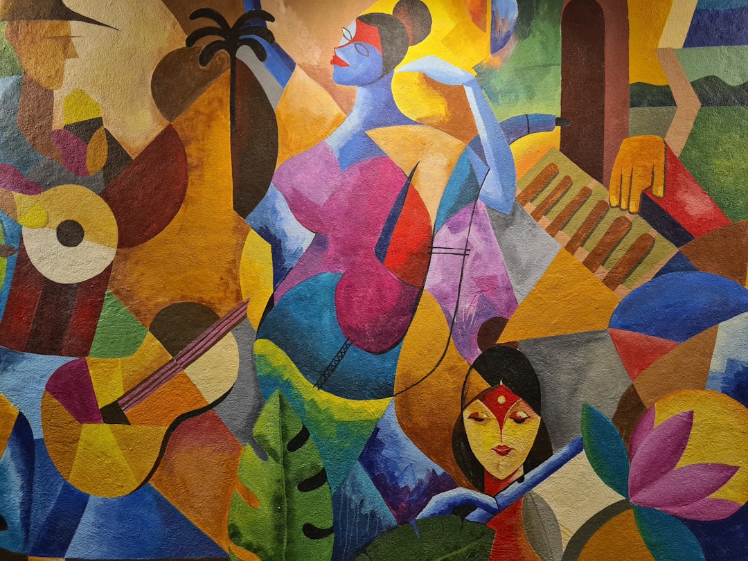 Close view of an artist's hands filling bold colors into a traditional Madhubani painting motif