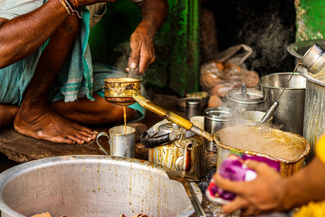A man holding a traditional dabara-tumbler set filled with freshly prepared South Indian filter coffee