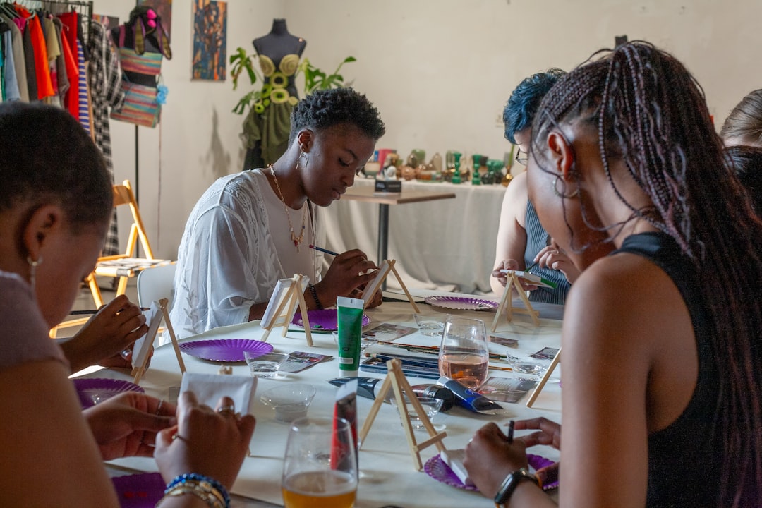 A student in a workshop practicing Madhubani painting techniques guided by an experienced teacher