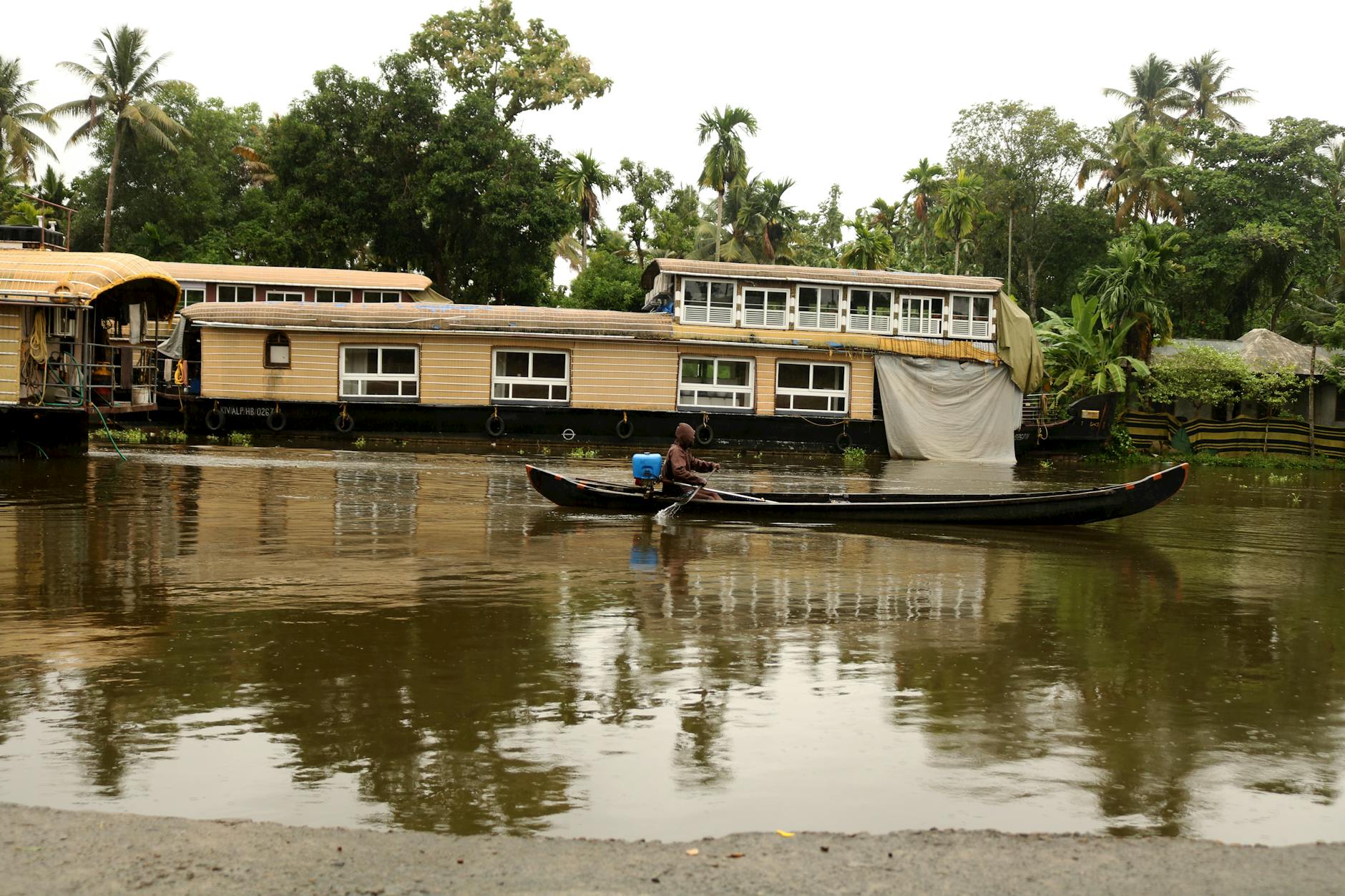Visitors on a traditional houseboat exploring Kerala backwaters during India monsoon travel