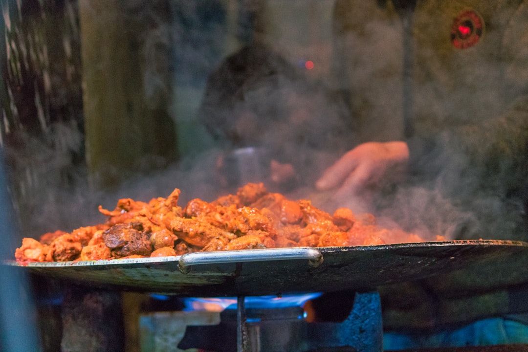 An Indian chef preparing a traditional coastal cuisine seafood curry with coconut and spices