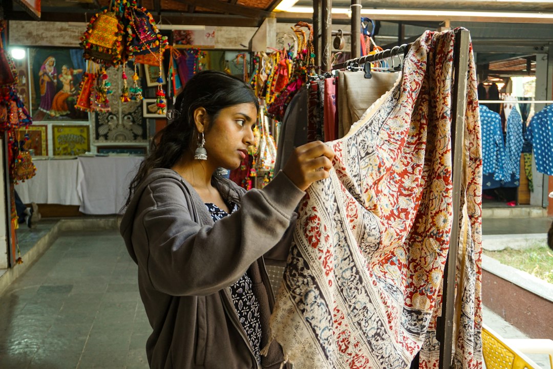 A female entrepreneur inspects handmade textiles before packaging them for craft export to international buyers